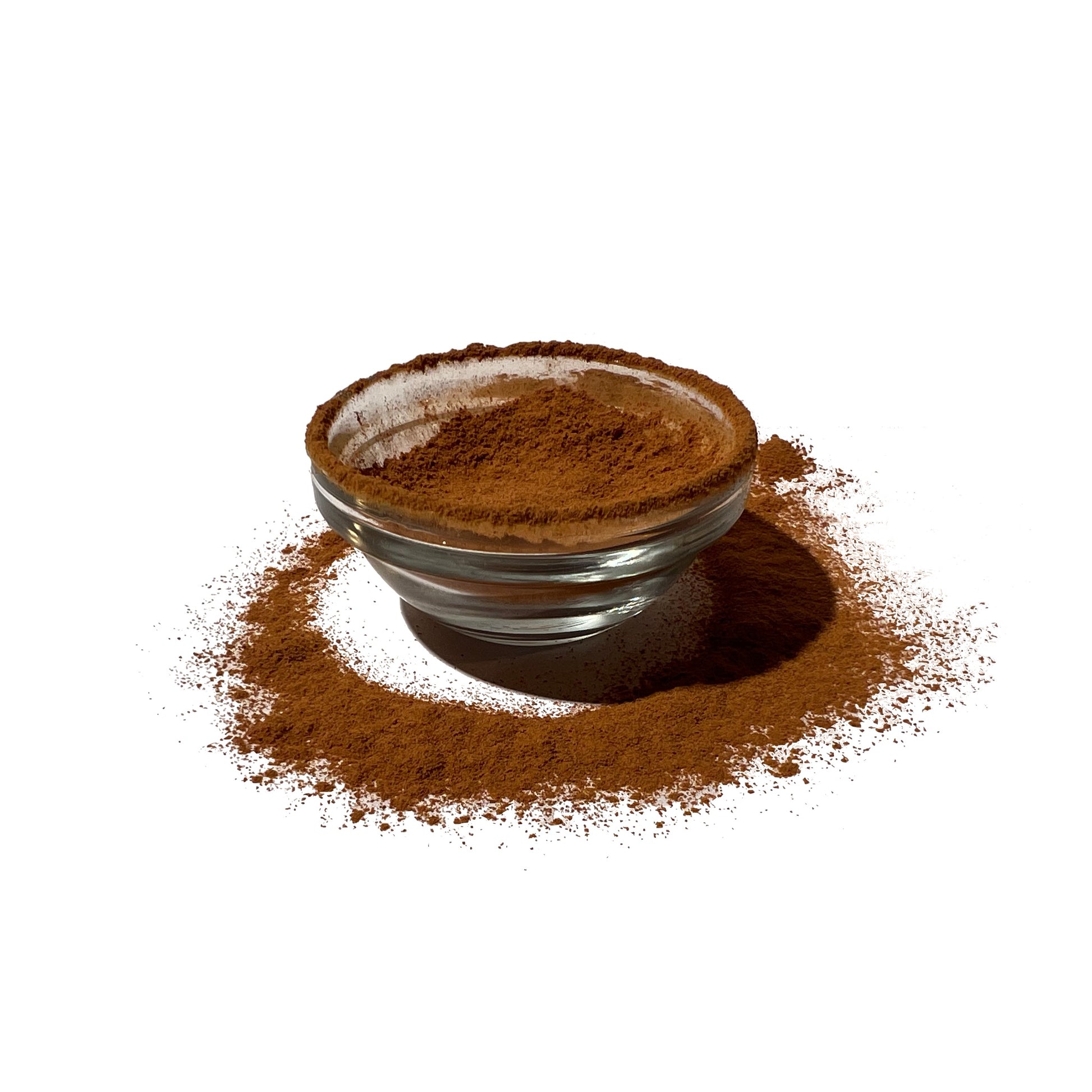 Cinnamon powder in and dusted around a small glass bowl