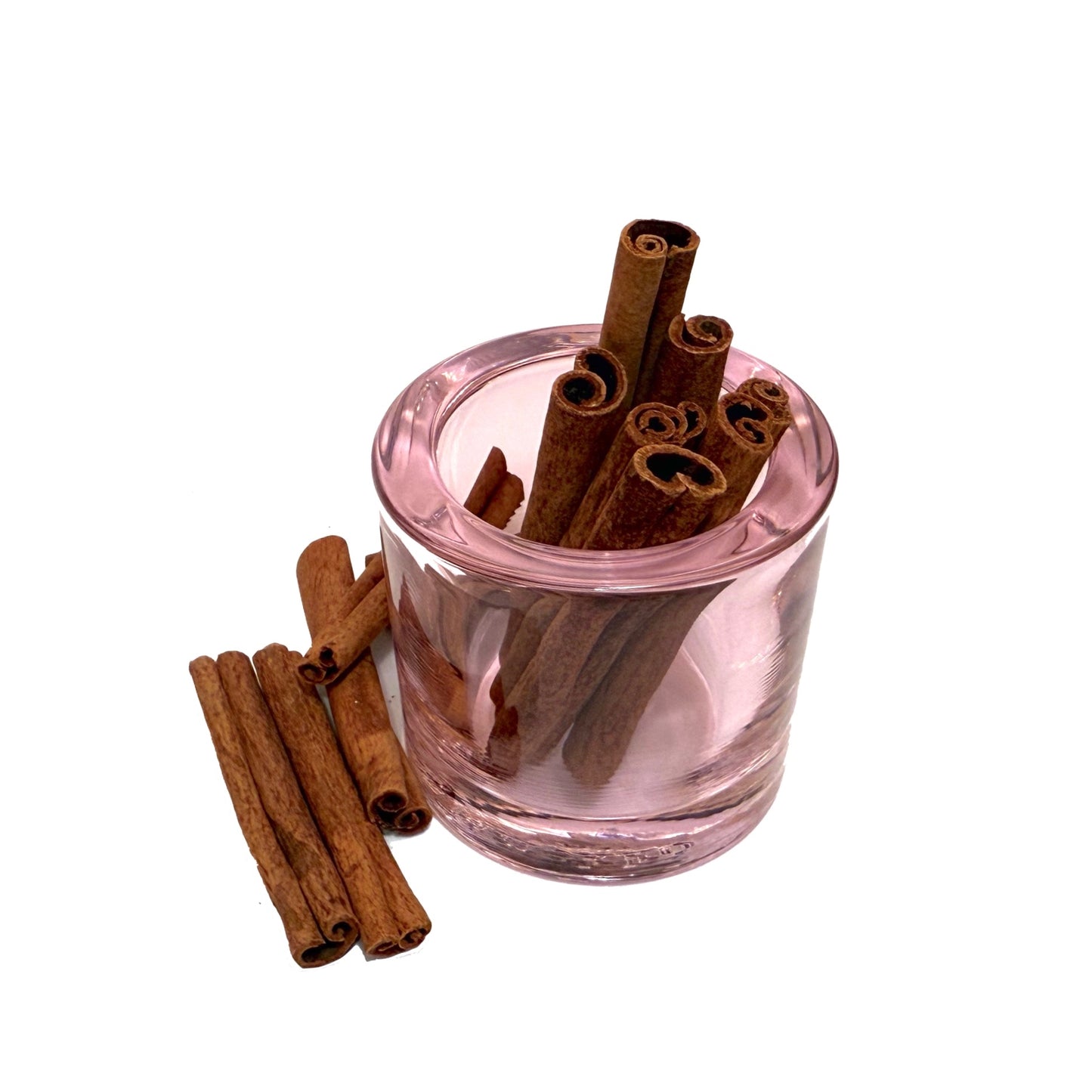Pink glass container filled with cinnamon sticks on a white background
