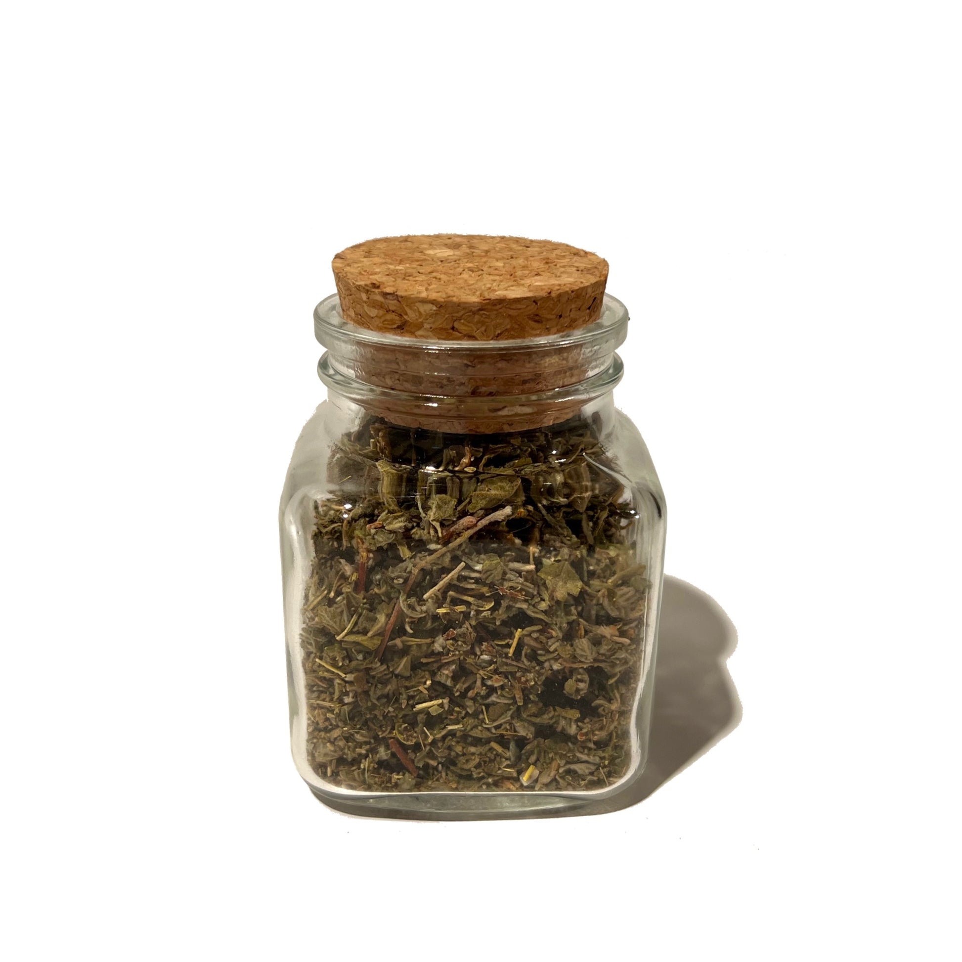 Small glass jar of dried damiana leaf with round cork stopper