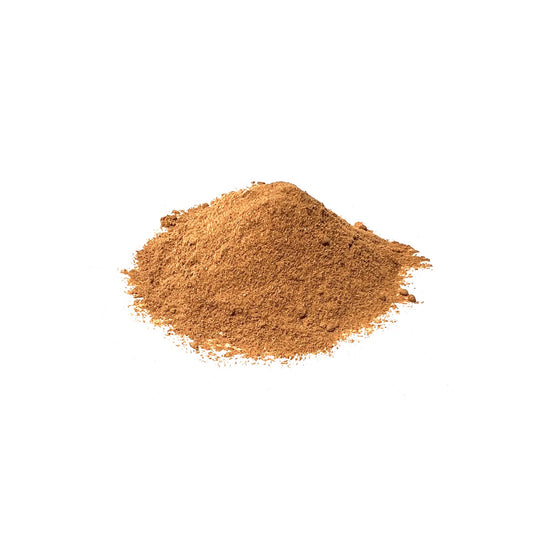 Golden dandelion root powder piled on a white background
