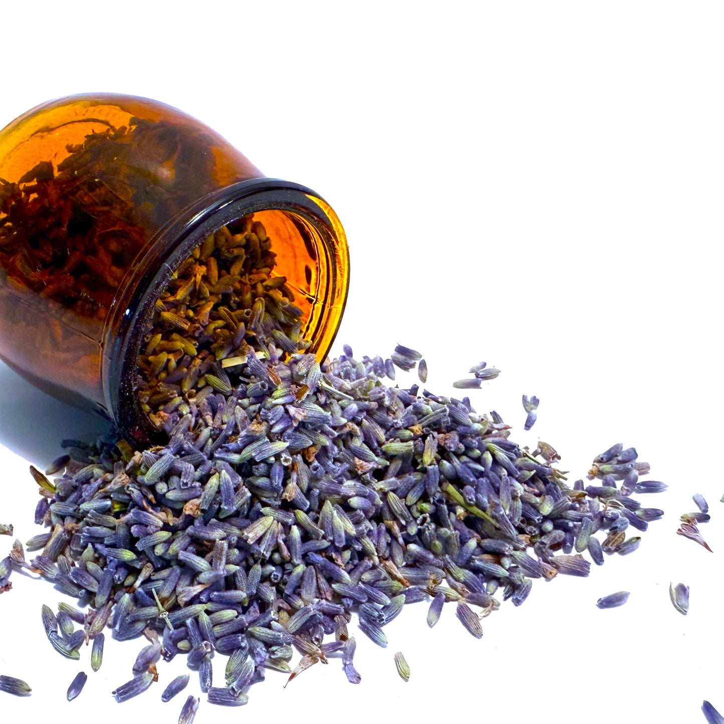 Purple lavender flowers spilling from overturned brown glass jar