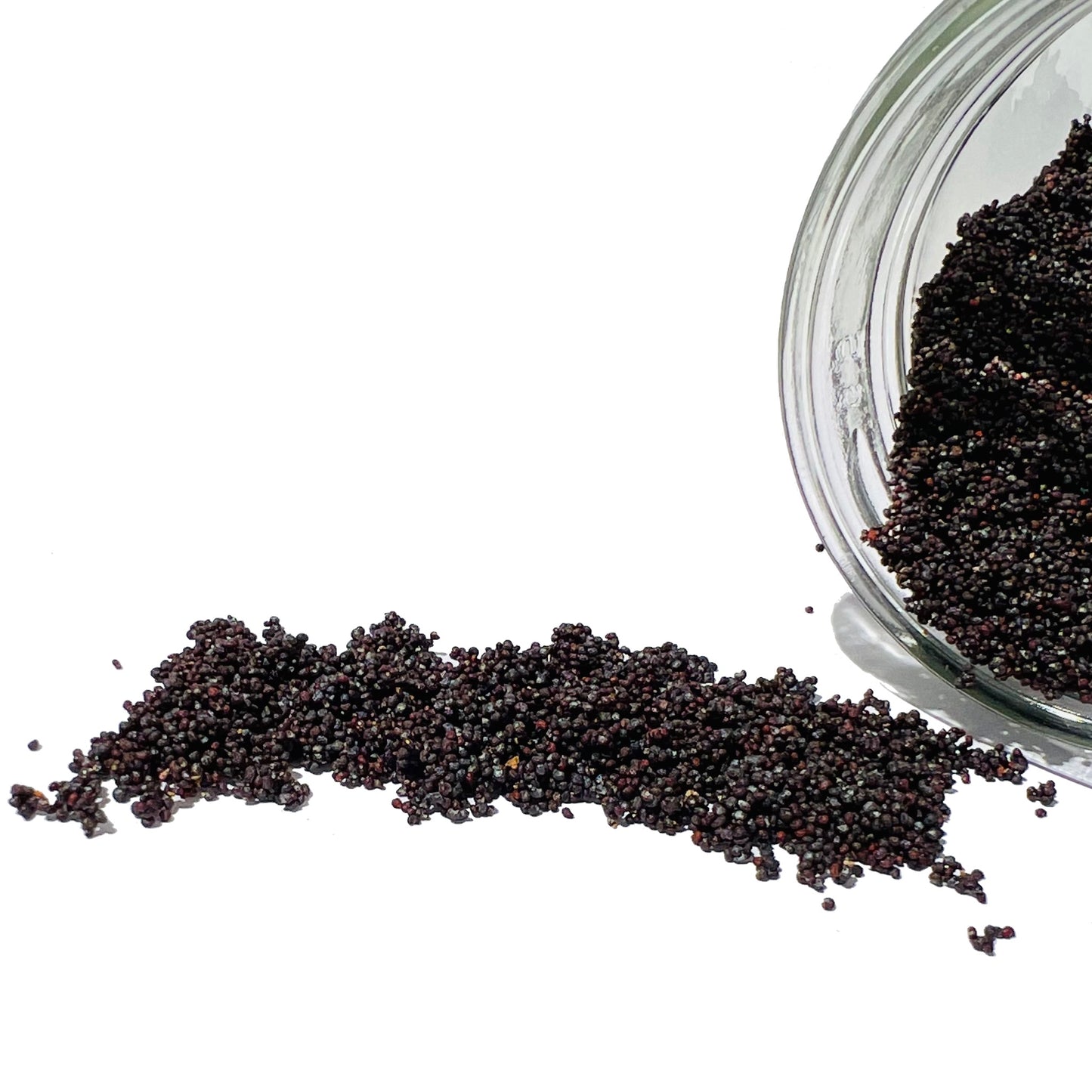 Thousands of poppy seeds spilling from a glass jar