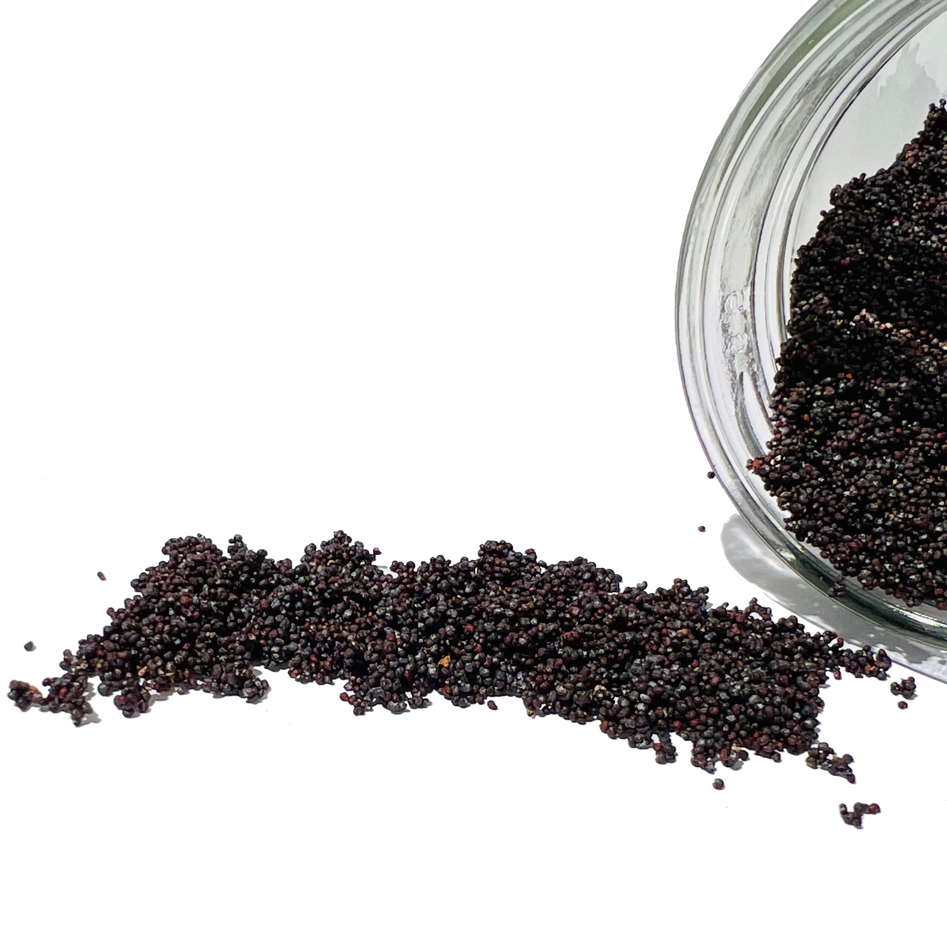 Thousands of poppy seeds spilling from a glass jar