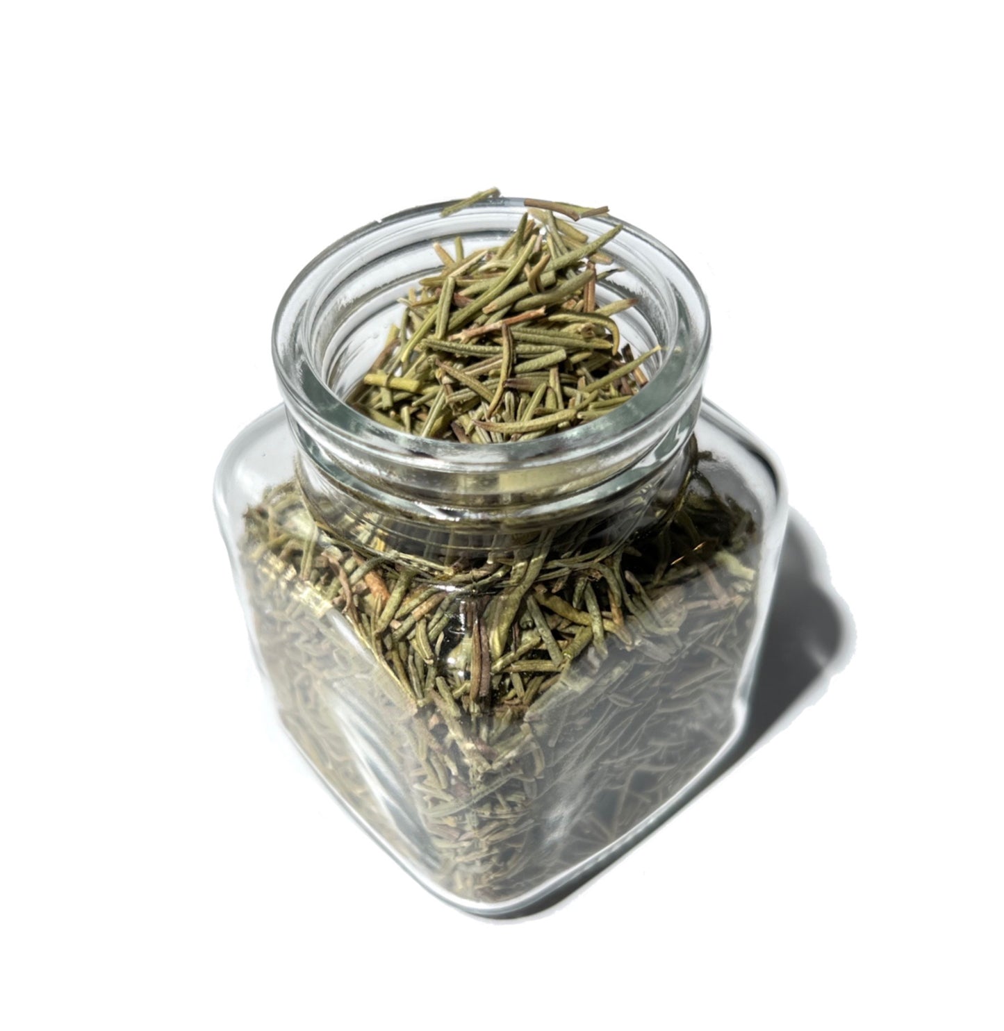 Dried rosemary leaves in a small, square glass jar.