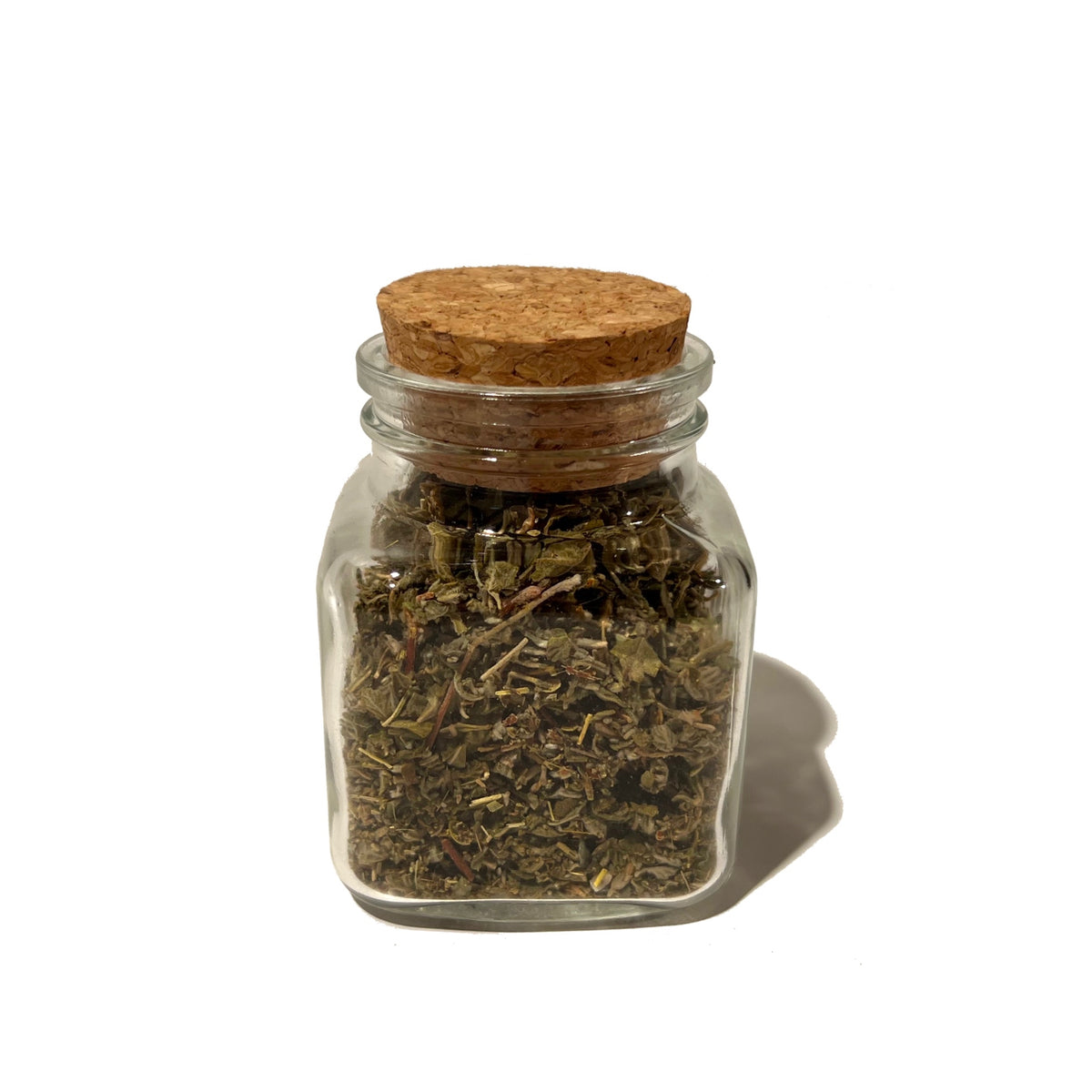 Small glass jar of dried damiana leaf with round cork stopper
