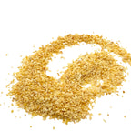 A scattered pile of small, irregularly shaped golden-yellow garlic flakes arranged on a solid white background.