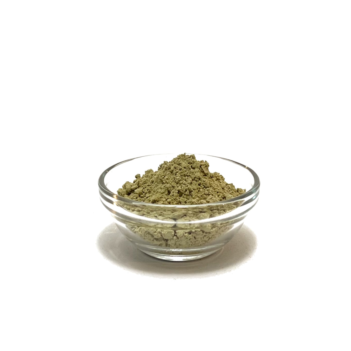 Small glass bowl filled with green kelp powder on a white background