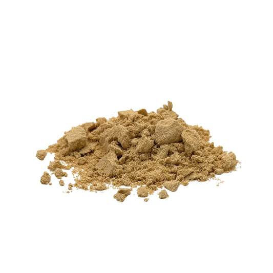 A small mound of fine, clumpy, light brown mushroom powder on a plain white background.