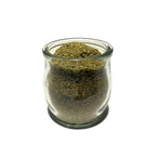 Small glass jar, no lid, full of dried green alfalfa leaf powder