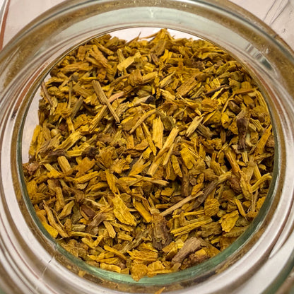 Close-up of a glass jar filled with dried yellow bark pieces on a white background