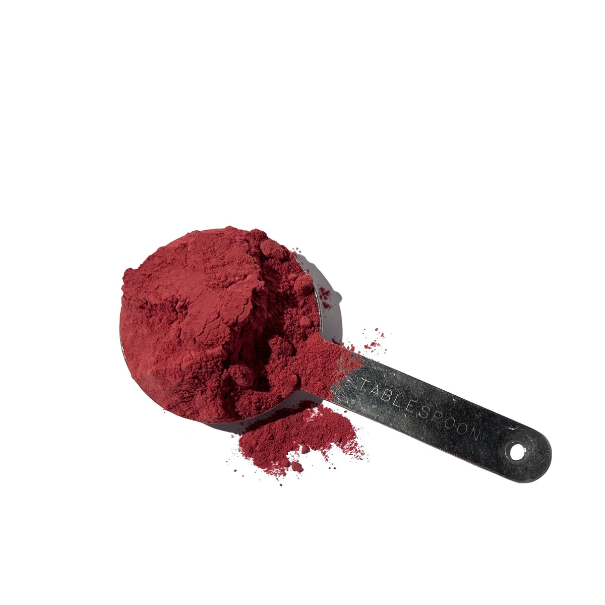 Bright red beet root powder in a heaping stainless steel tablespoon
