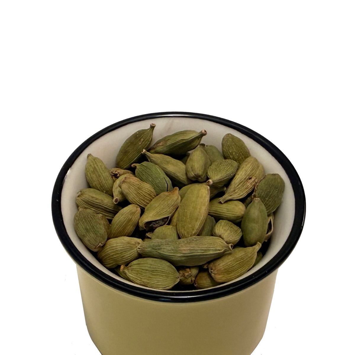 Dried cardamon pods in a vintage green, black rimmed cup