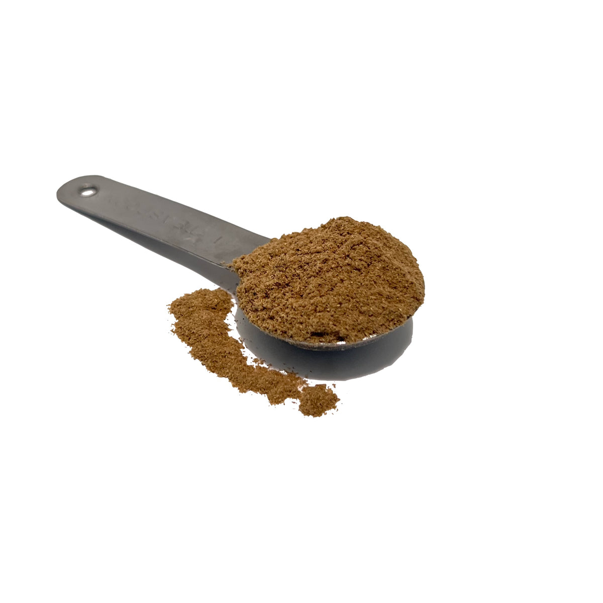 Metal teaspoon overflowing with medium brown chamomile powder.