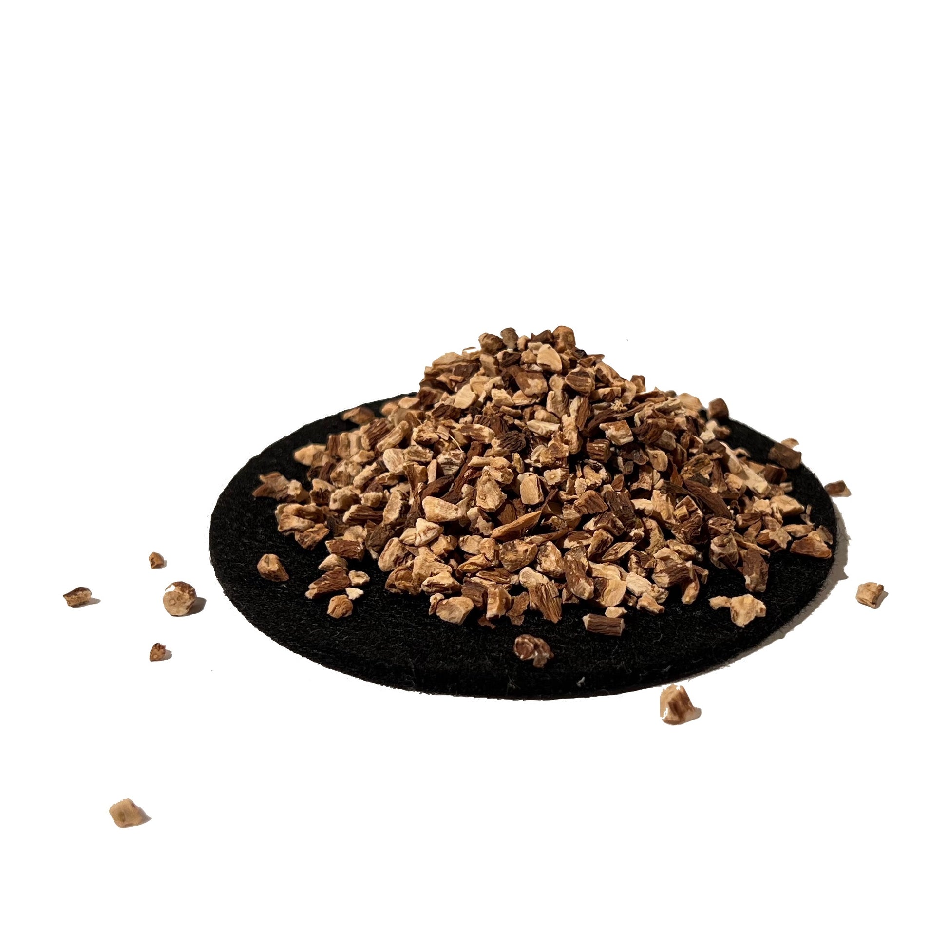 Beige and brown dandelion root cuts, piled on a black tray