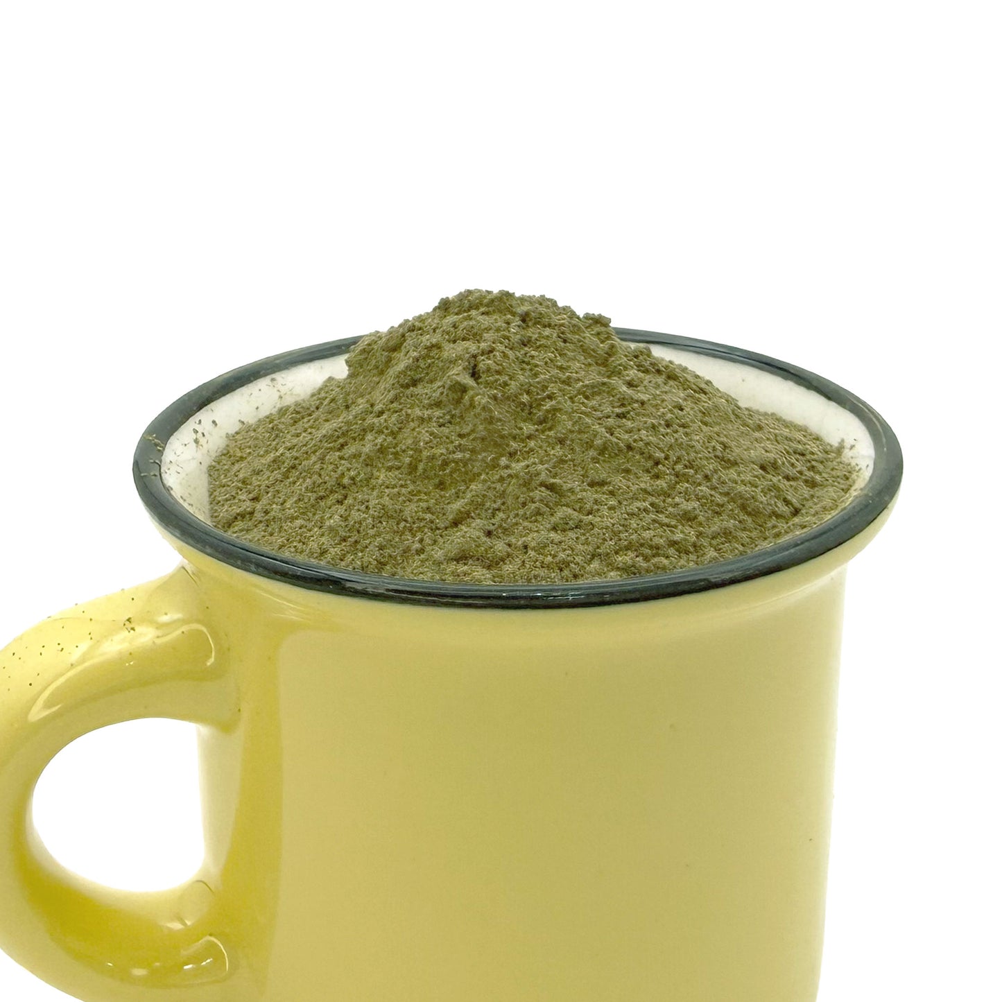 A yellow ceramic mug with a dark rim filled with a mound of green tea leaf powder, shown against a plain white background.