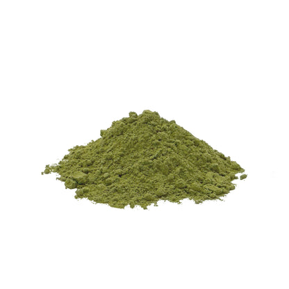 A small mound of green kale powder centered on a plain white background.
