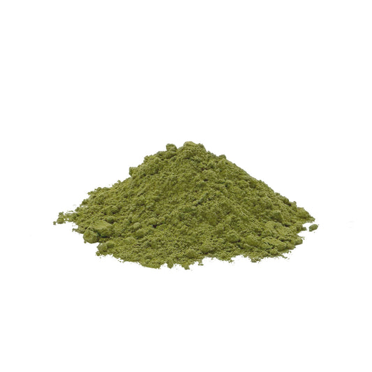 A small mound of green kale powder centered on a plain white background.