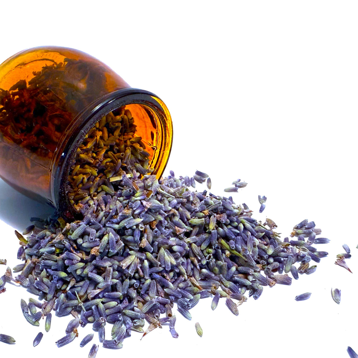 Purple lavender flowers spilling from overturned brown glass jar