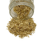 Dry cut and sifted passion flower herb spilling out of a clear glass jar against a solid white background.