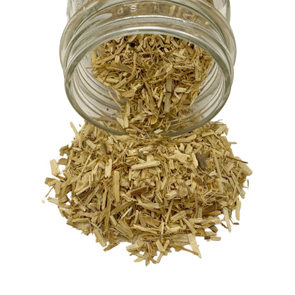 Dry cut and sifted passion flower herb spilling out of a clear glass jar against a solid white background.