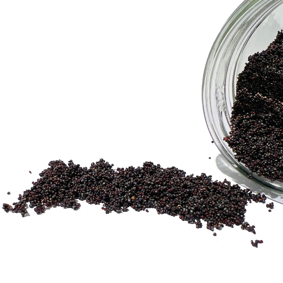 Thousands of poppy seeds spilling from a glass jar