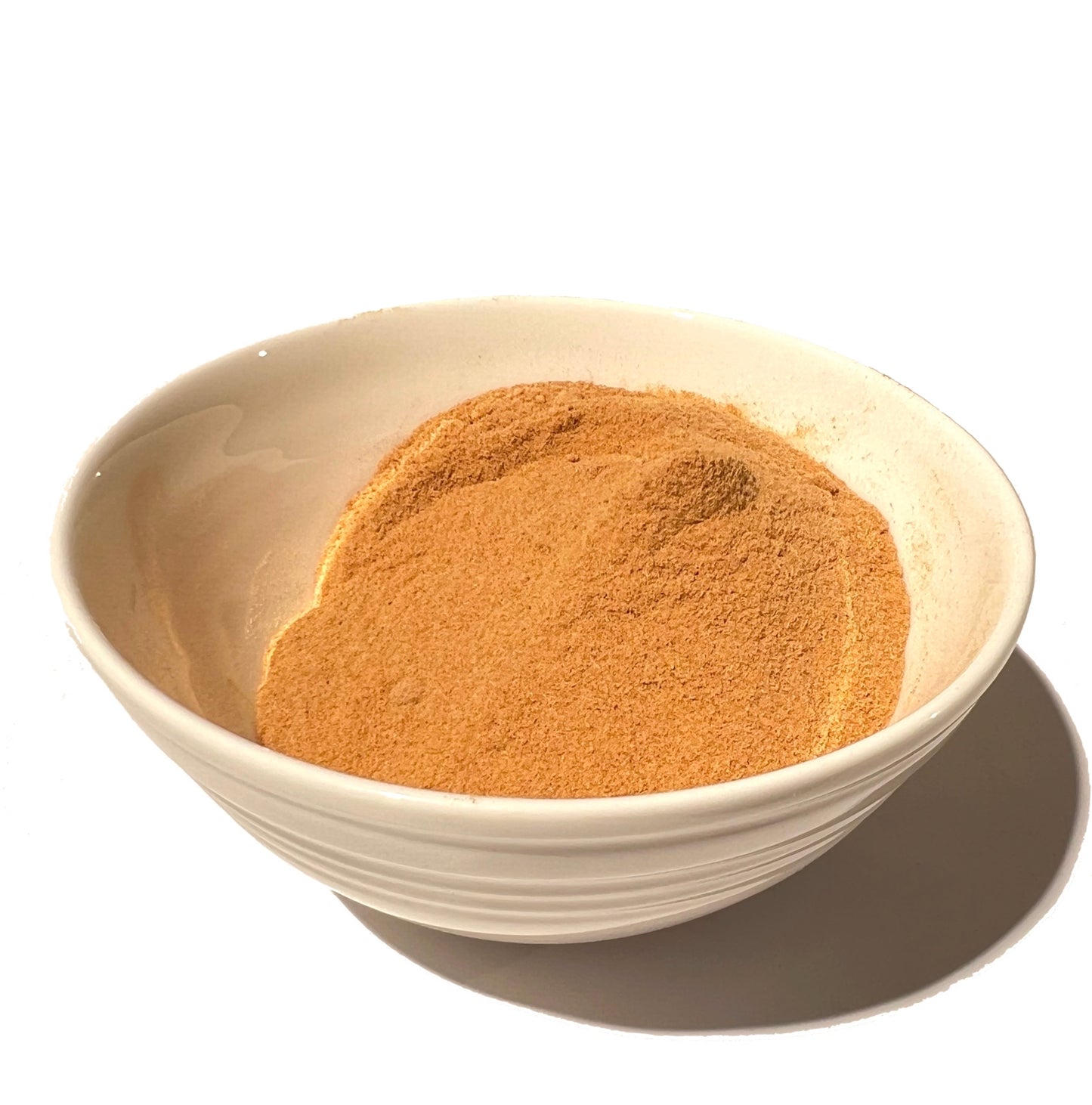 Off-white ceramic bowl partially filled with rose hip powder