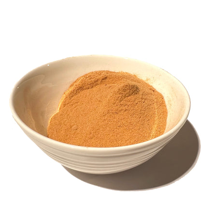 Off-white ceramic bowl partially filled with rose hip powder