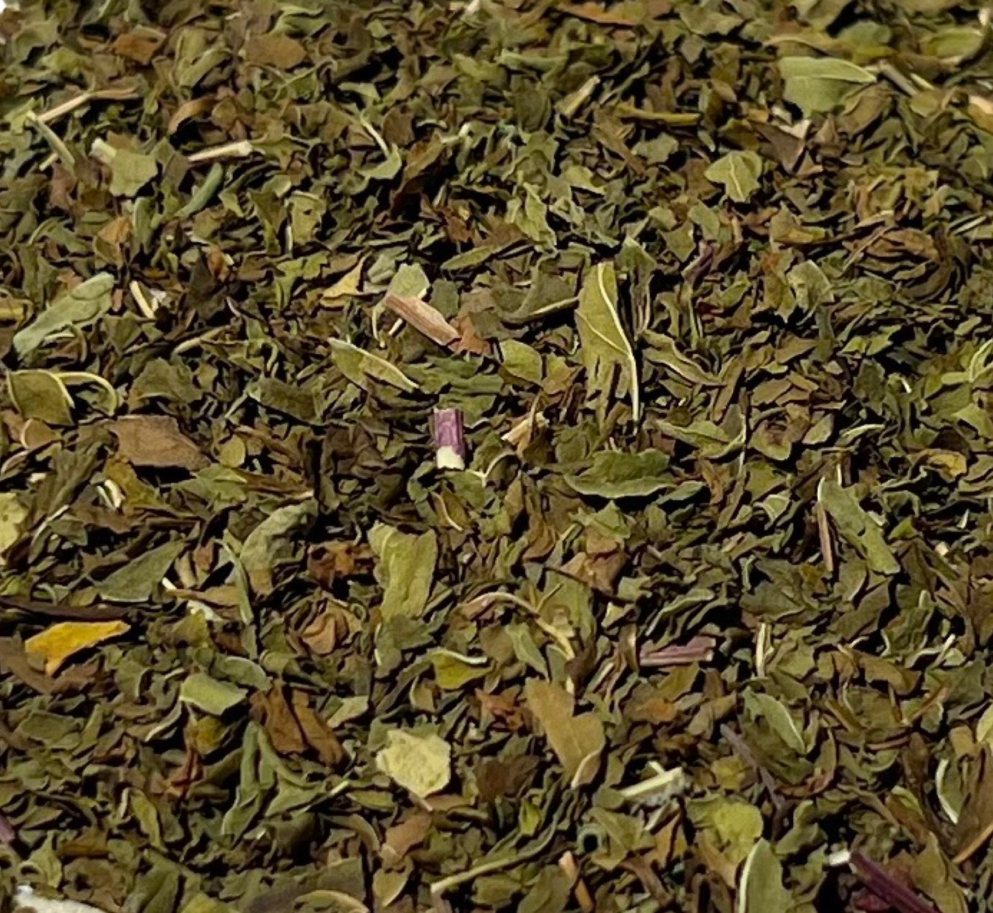 Detail of dark green and olive-tone rubbed spearmint leaves