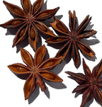 Detail of four reddish-brown star anise pods with seeds